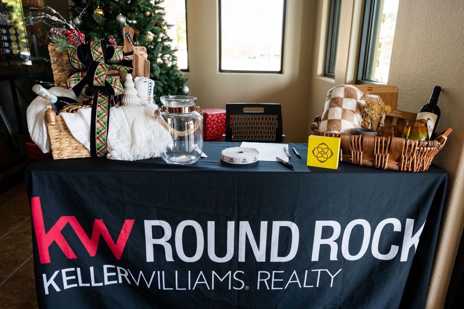 A Keller Williams Realty table display with Christmas decorations and promotional materials.