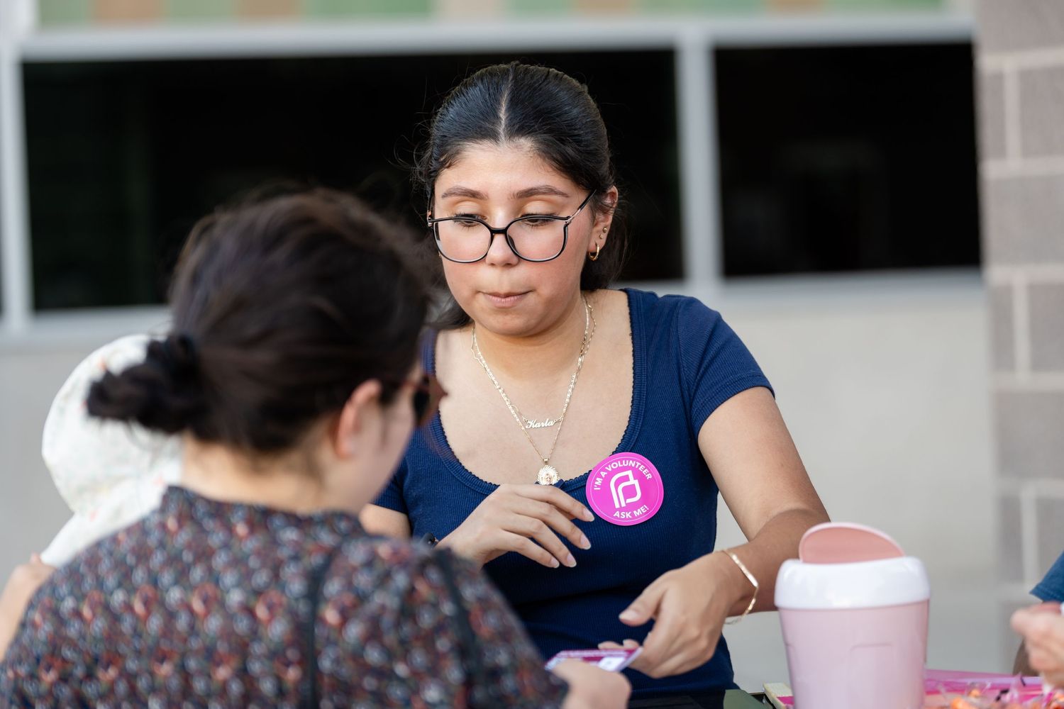 Two event attendees engaged in conversation at an outdoor gathering.