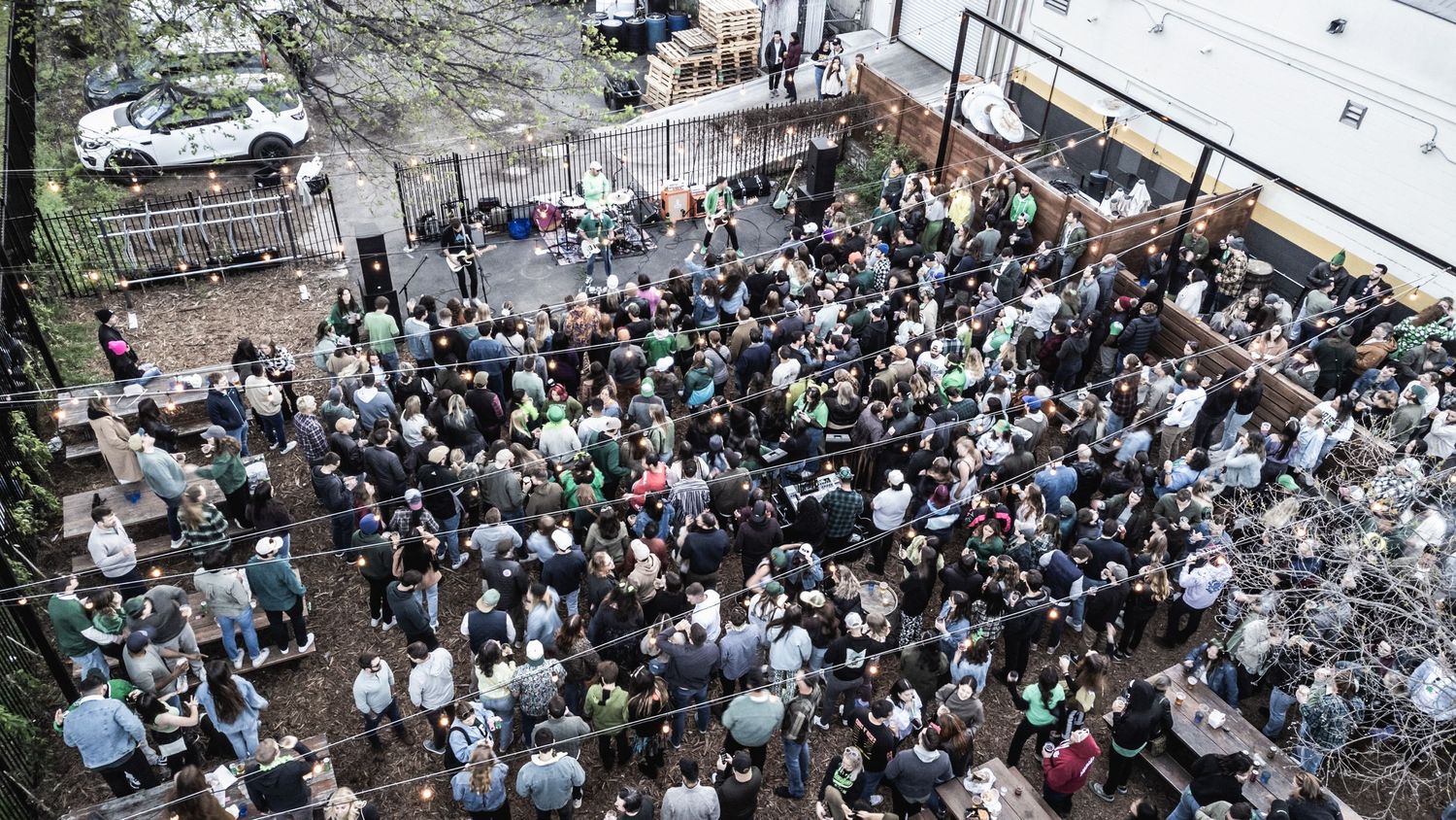 Birds-eye view of packed outdoor venue showing dense crowd during daytime event.