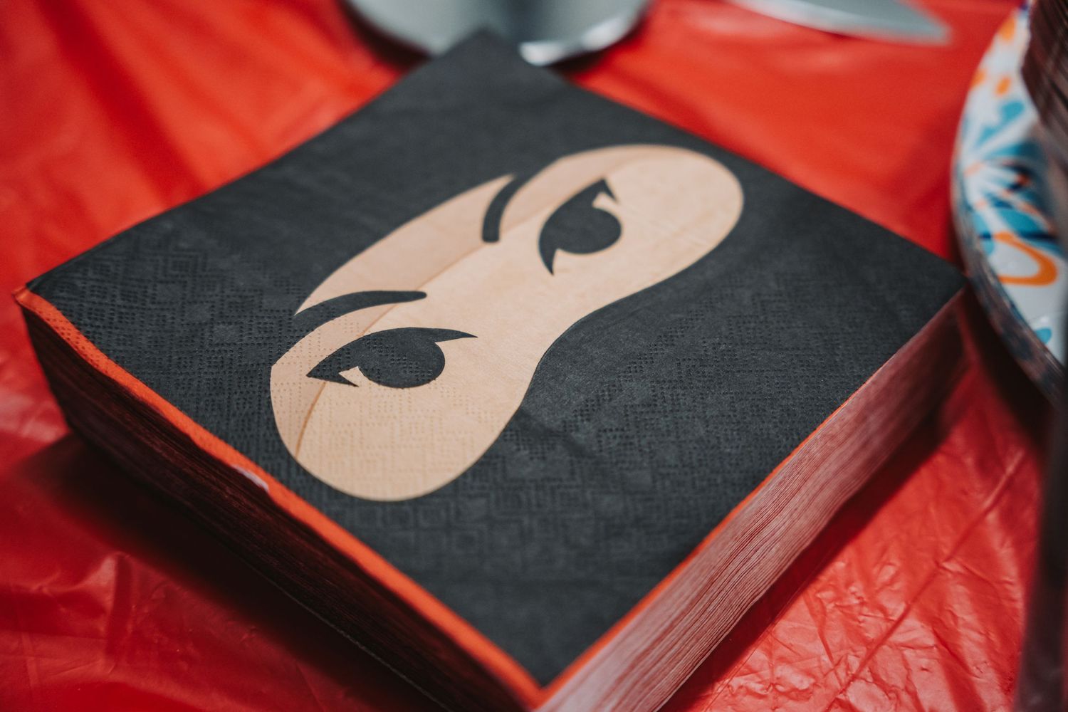 Black book cover with minimalist eye mask design on red background.