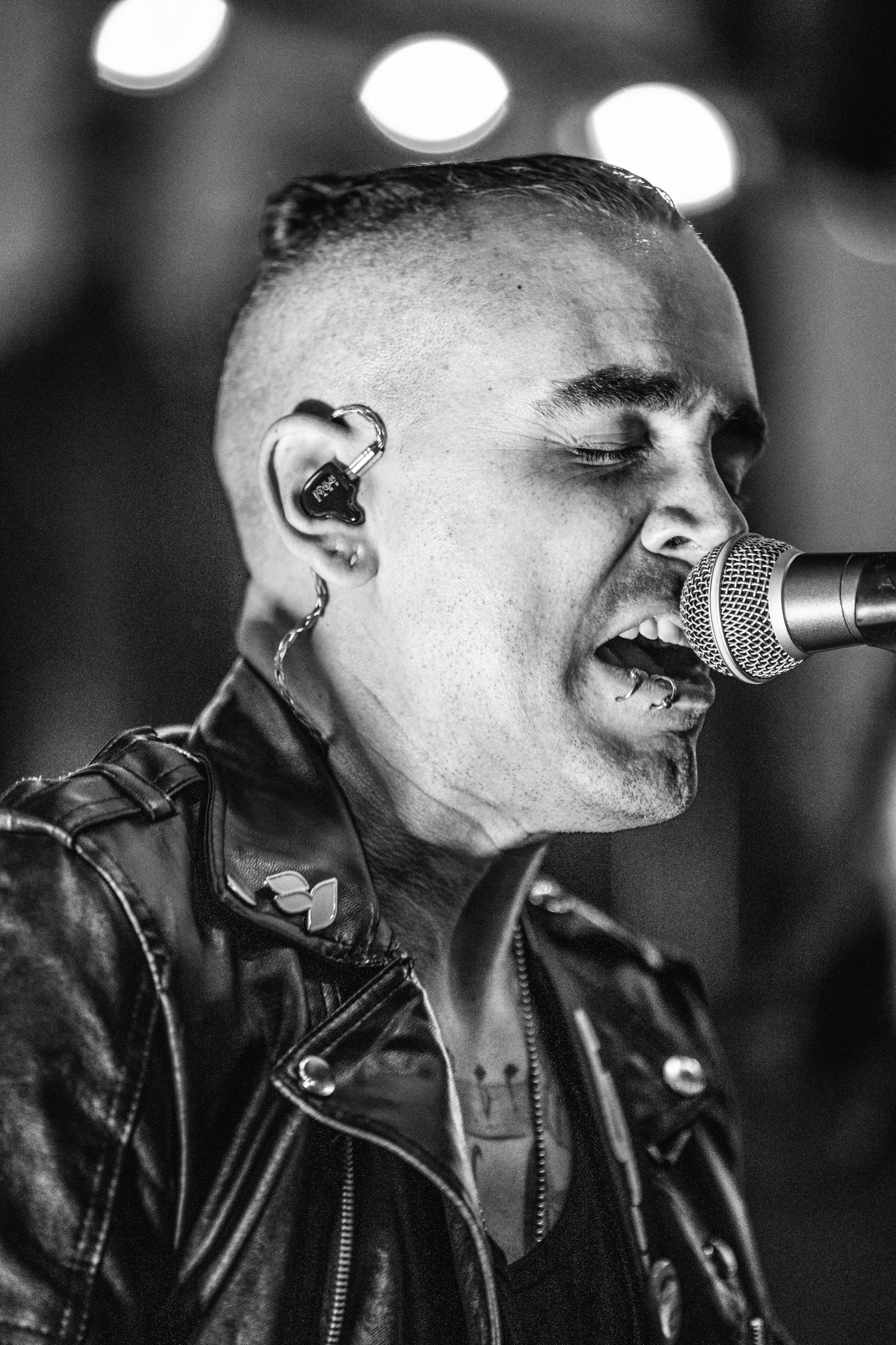 Black and white close-up of performer singing into microphone.