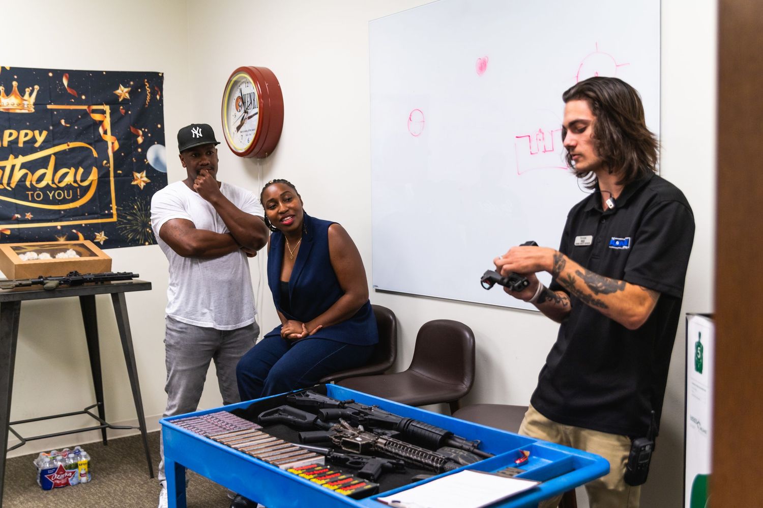 Shooting range instructor demonstrating firearm safety during a birthday celebration event.