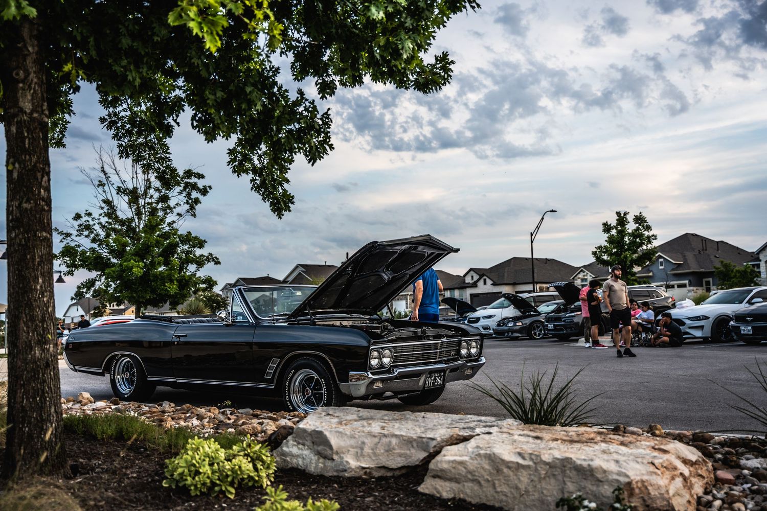 Vintage black convertible car displayed at an outdoor automotive meetup.