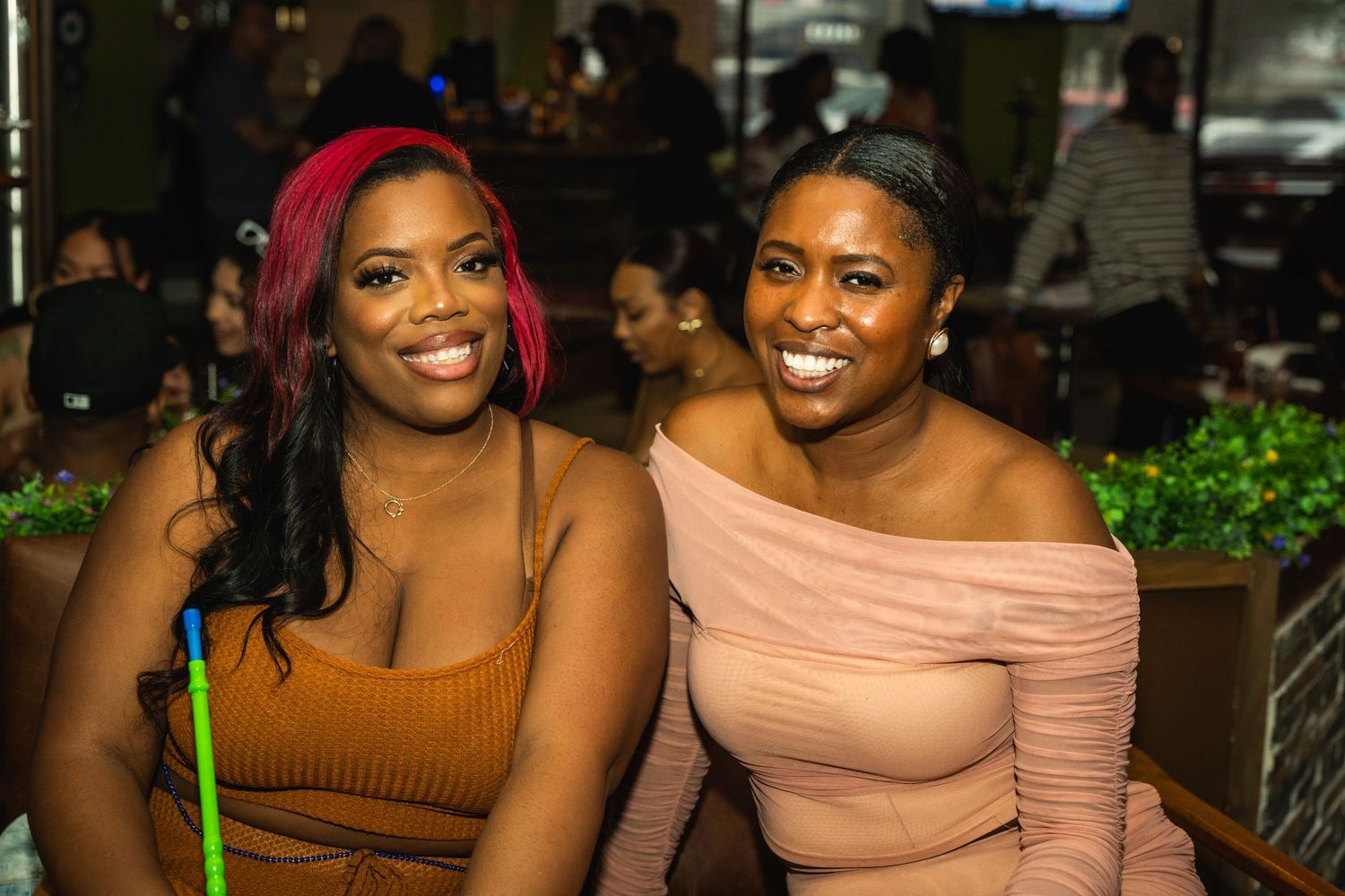 Two friends enjoying a night out at an outdoor restaurant.