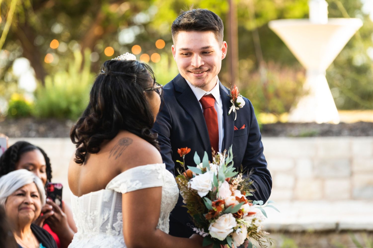 Wedding couple shares joyful moment during outdoor ceremony.