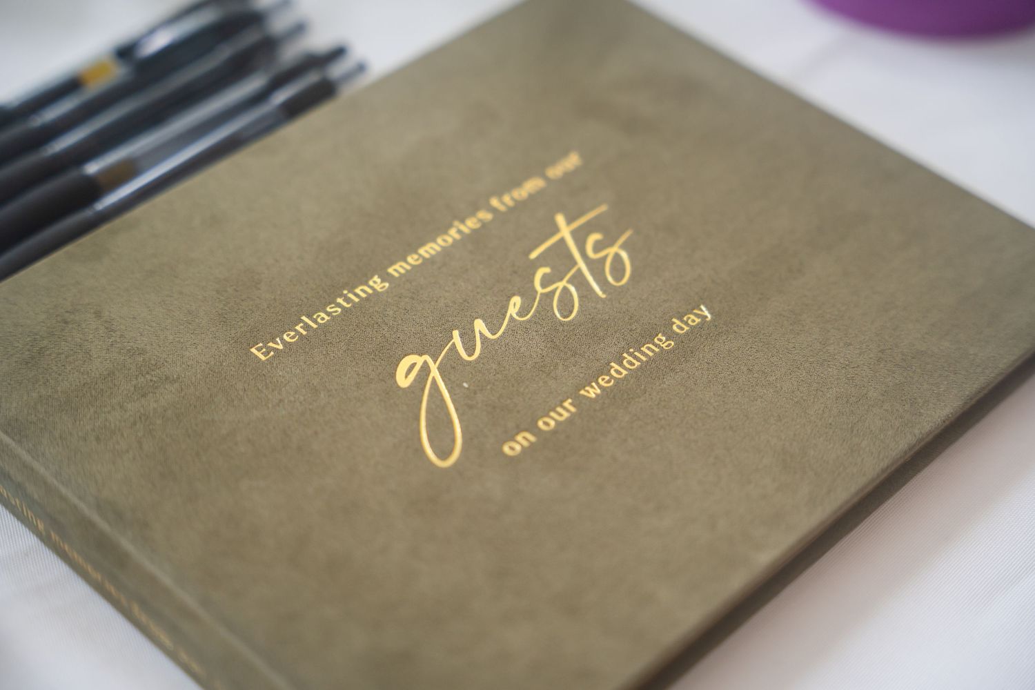 Gold foil wedding guest book with elegant script reading everlasting memories from our guests on our wedding day.