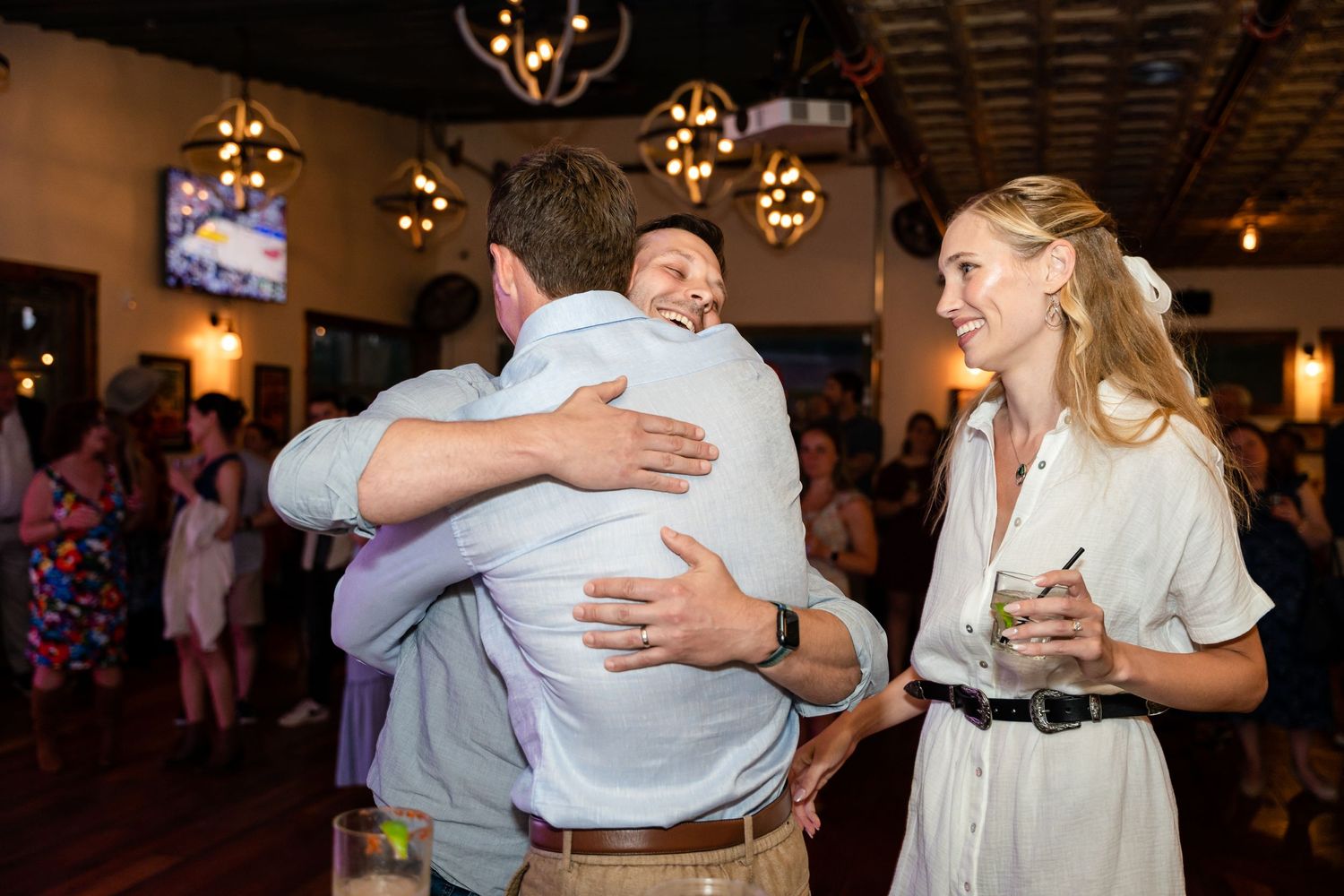 People sharing an emotional group hug during a celebration event.