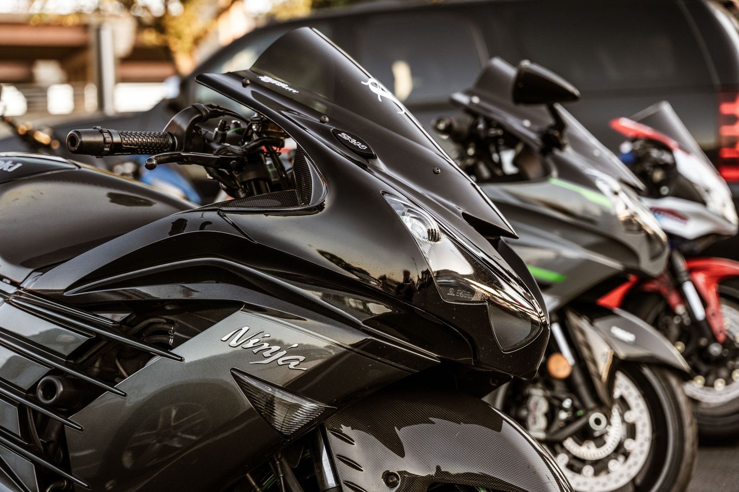 Close-up detail shot of black performance motorcycles lined up together.