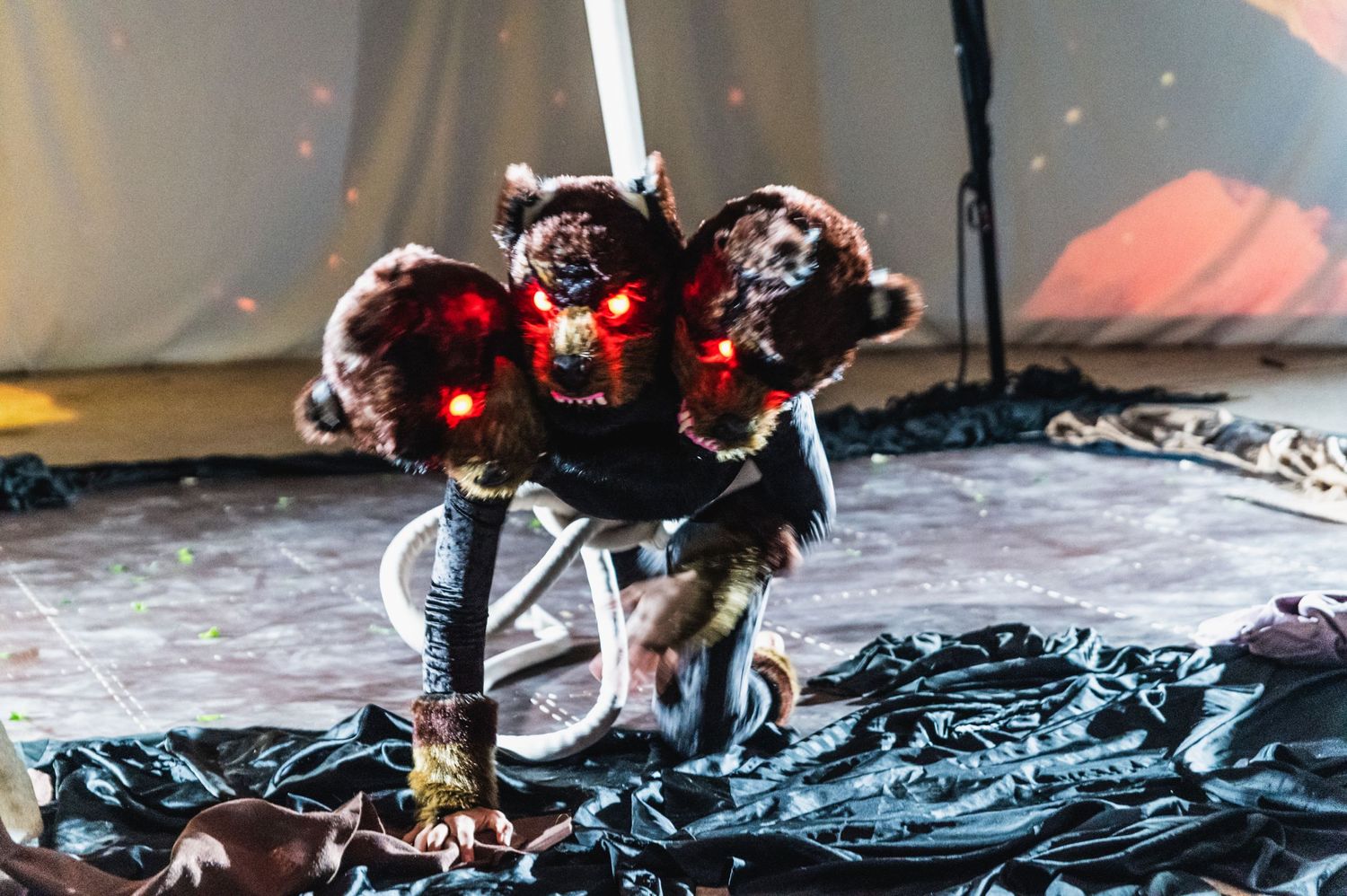 Dramatic low-angle performance shot with red lighting effects on dark stage.
