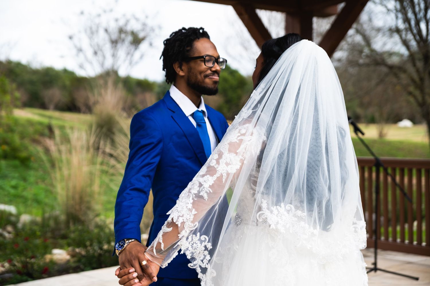 A romantic moment shared between newlyweds under a wooden pavilion during their wedding ceremony.