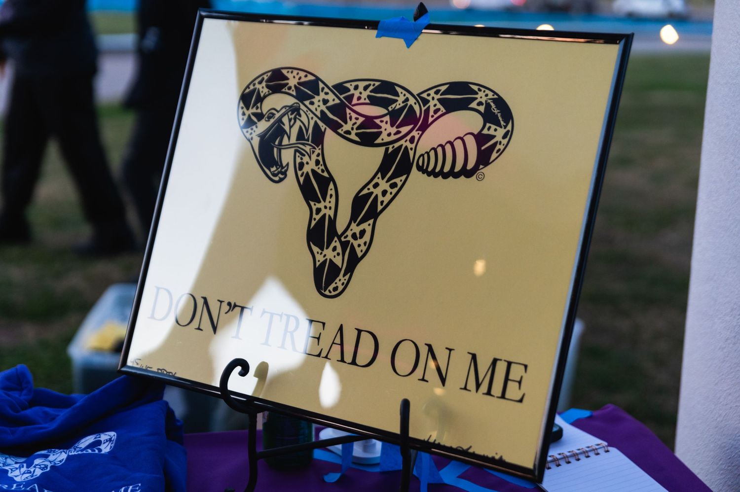 Decorative gold-toned uterus artwork display with text on stand.