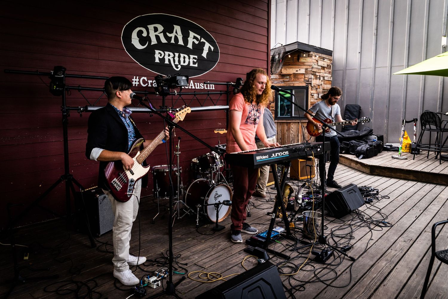 Band performs on wooden deck stage at Crab Pride Austin with full musical setup.