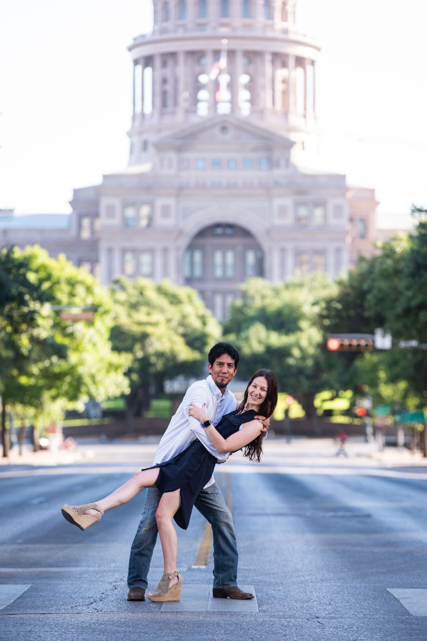 A playful dip pose on Congress Avenue with the Texas State Capitol in the background.