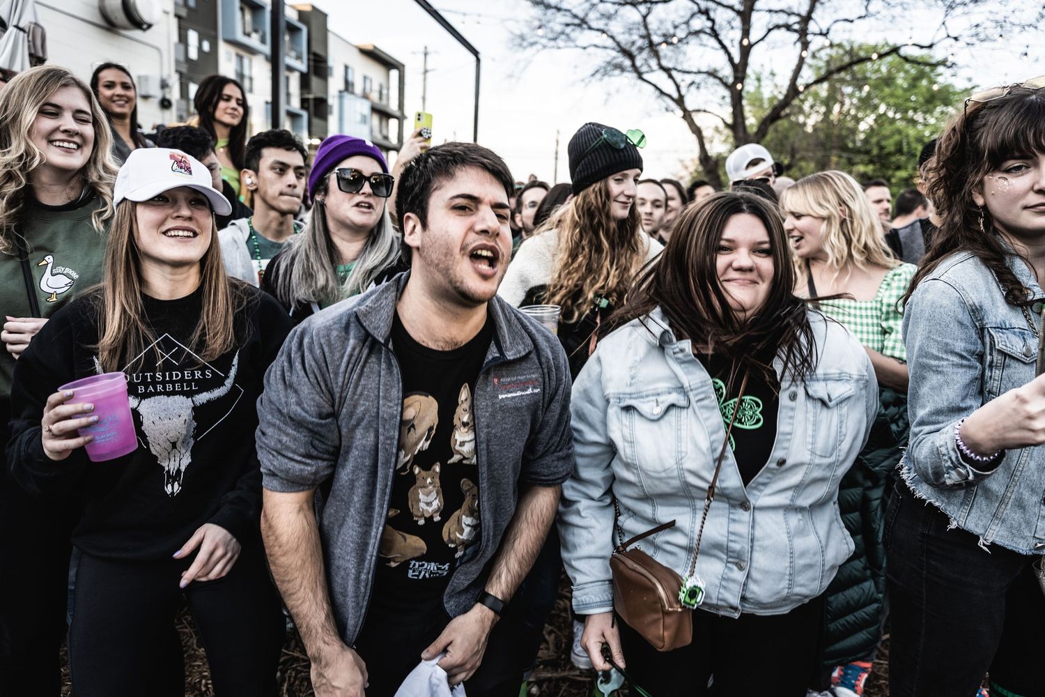 Enthusiastic crowd reacts with excitement at outdoor music festival event.