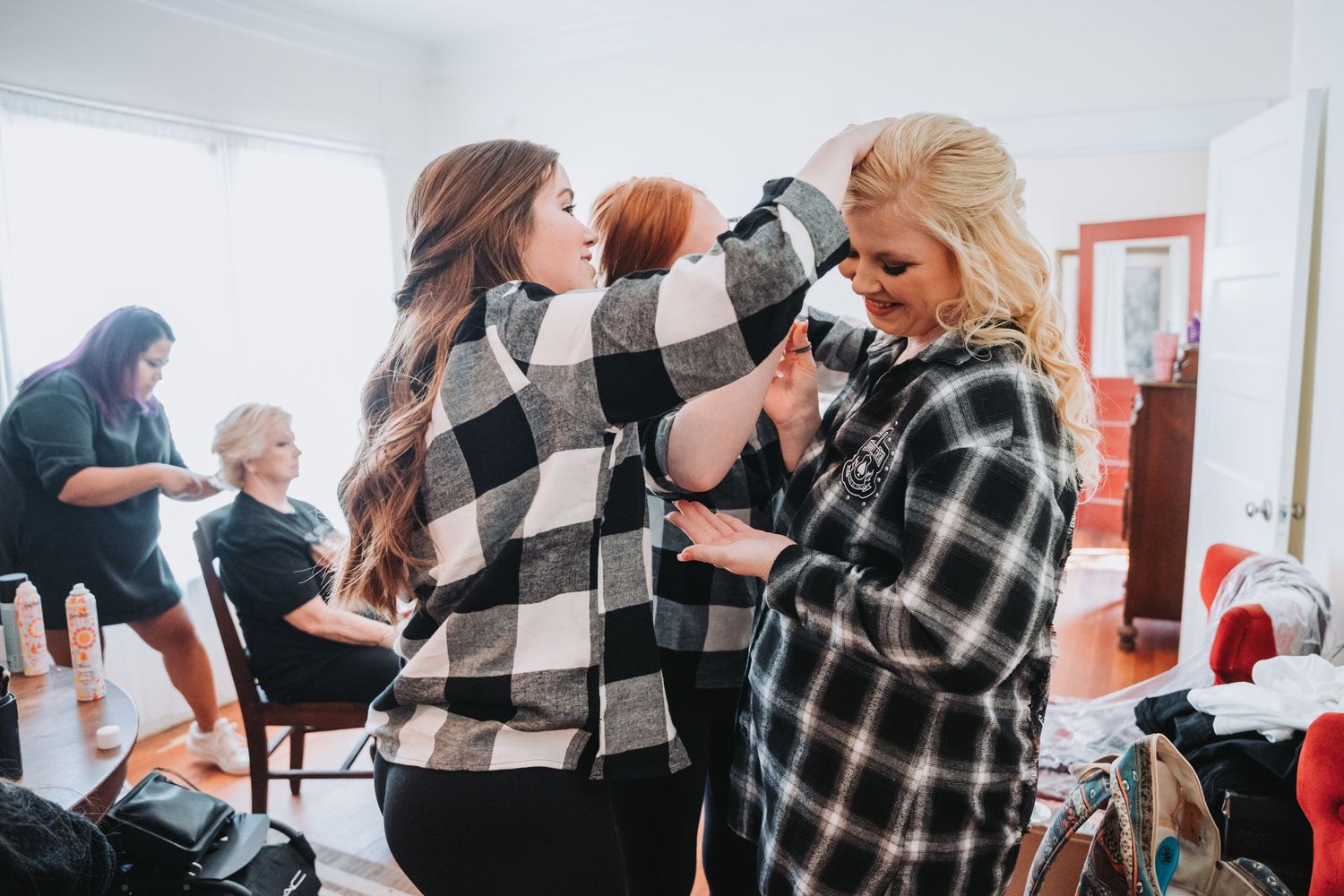 Group getting ready in matching black and white plaid flannel shirts before a wedding ceremony.