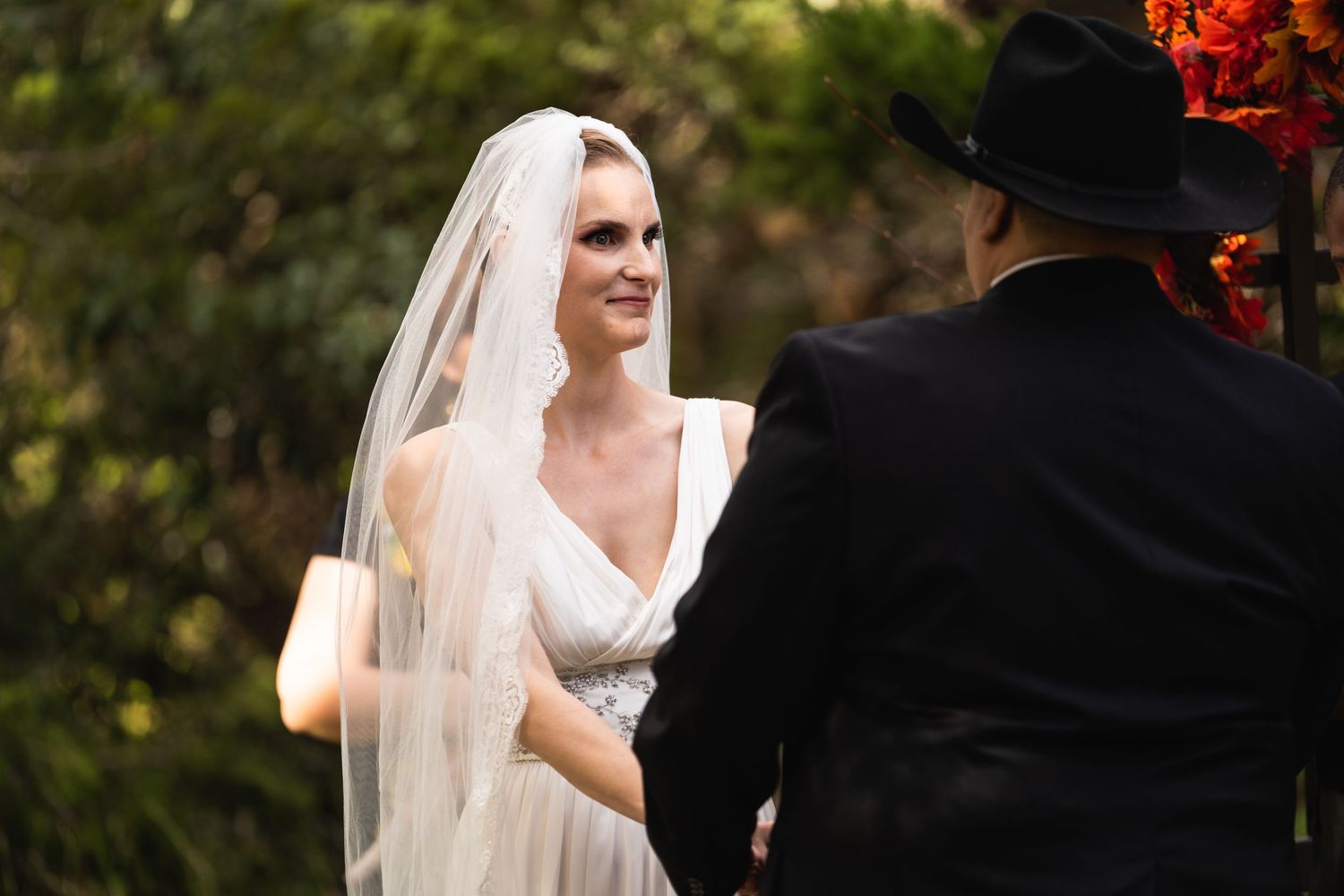 A tender exchange between participants during an outdoor wedding ceremony.