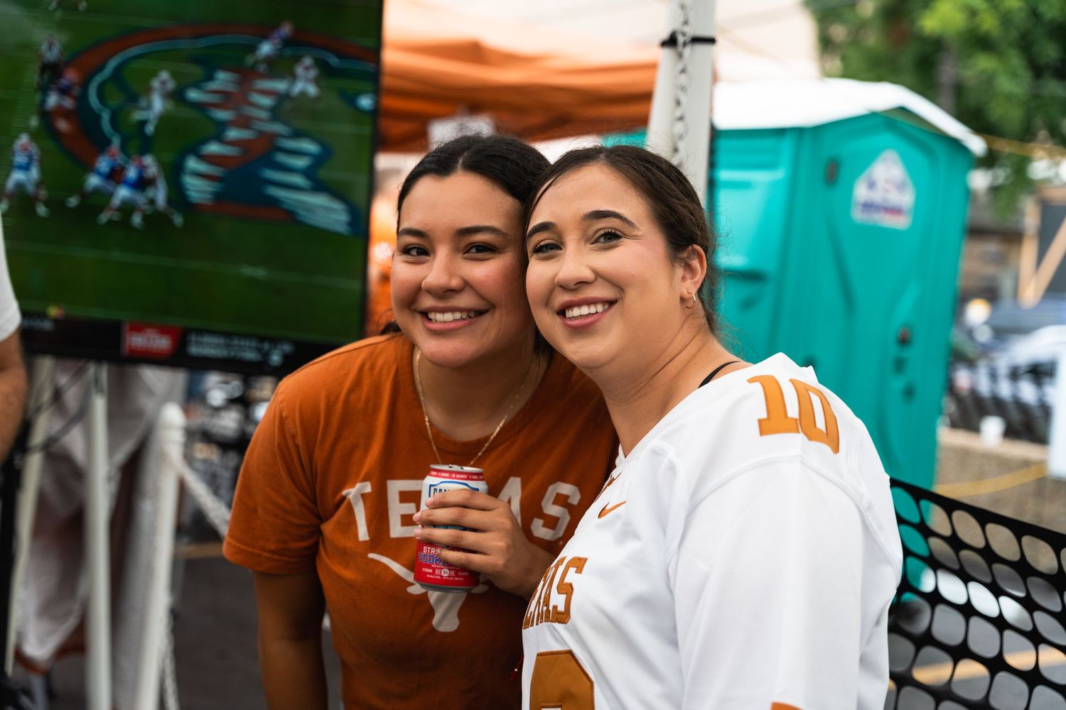 Texas sports fans celebrating at outdoor event wearing team colors.