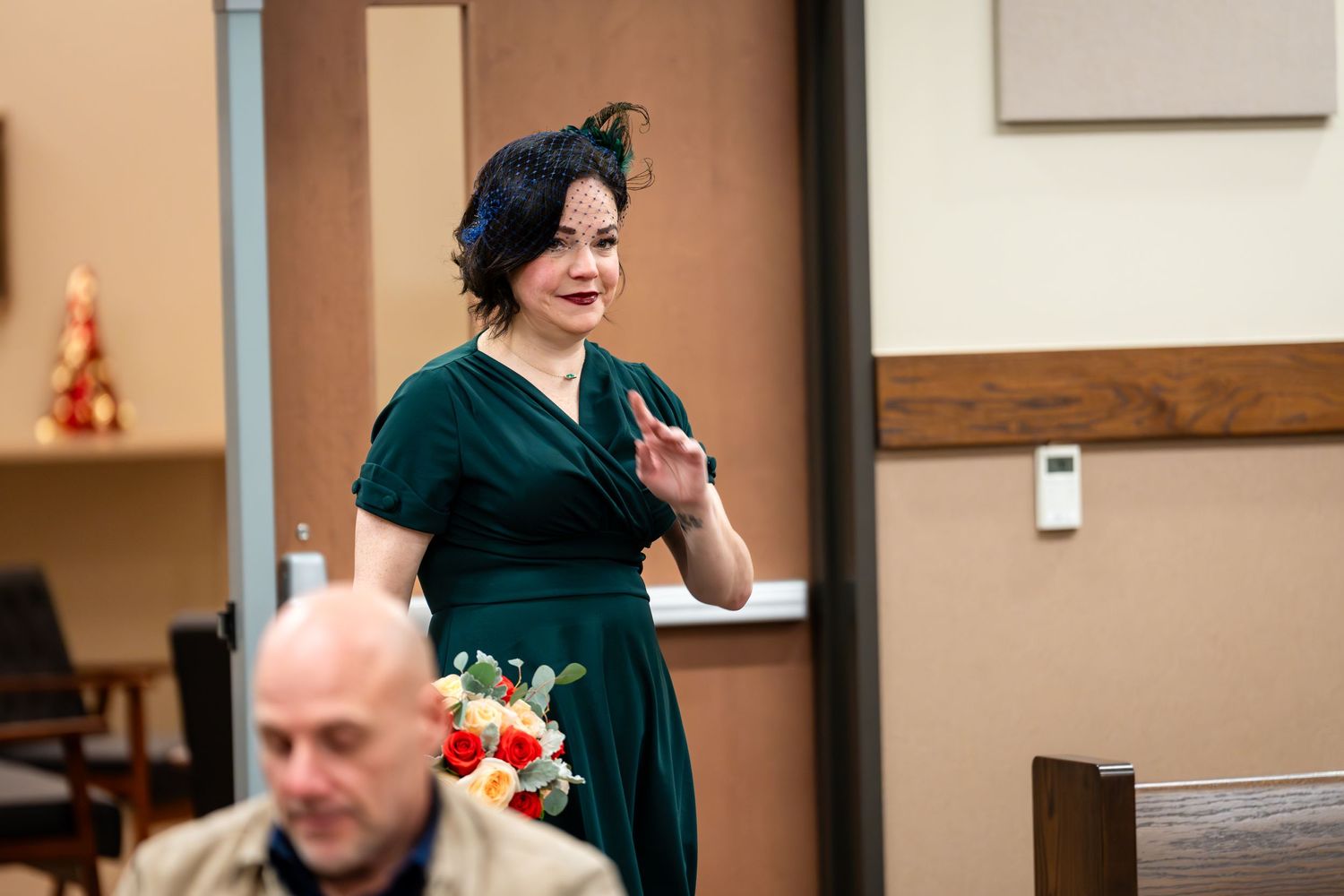 Person in green vintage dress speaks during formal event.