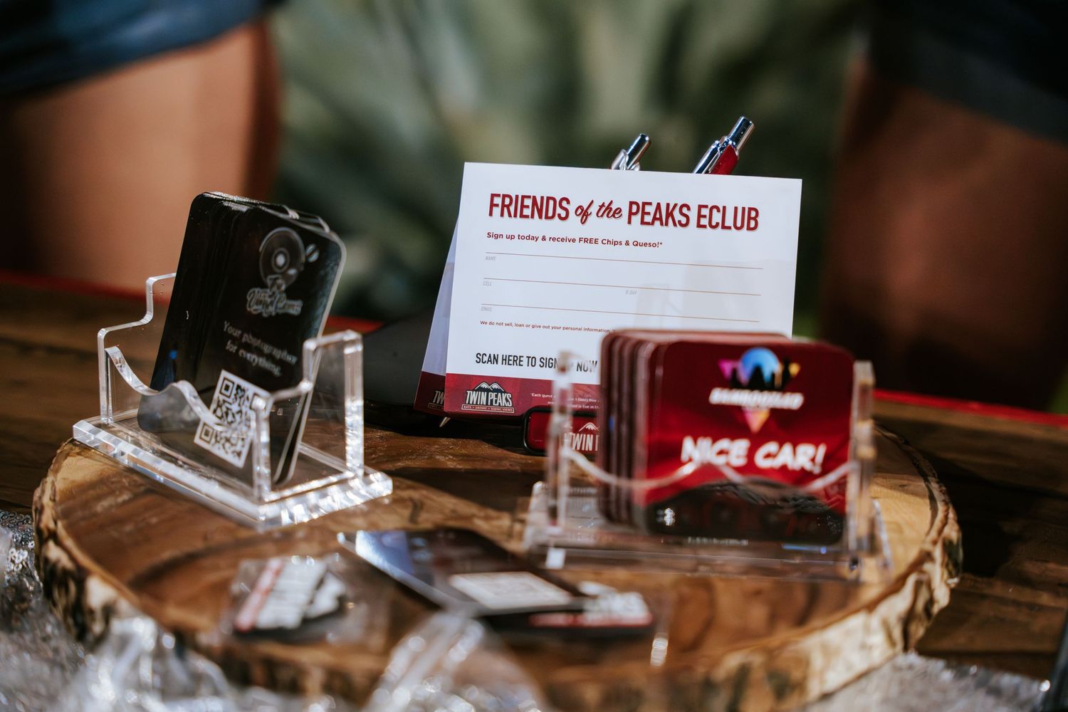 Close-up of car club membership cards and display items on a wooden surface.