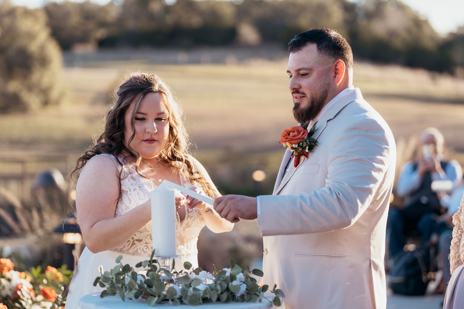 Happy couple sharing cake cutting moment at outdoor reception.