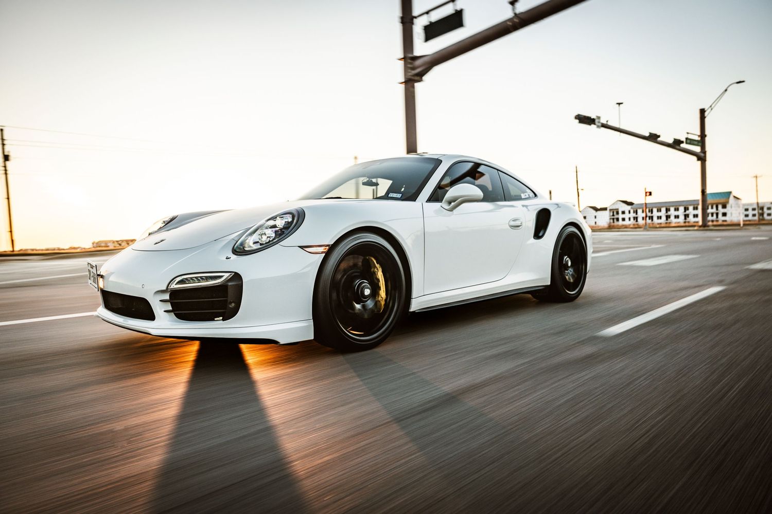 White Porsche 911 Turbo speeding on a highway during sunset with motion blur effect.