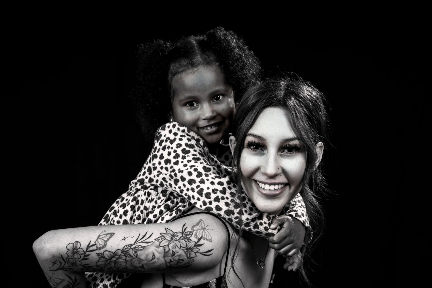Black and white photo showing warm embrace with matching animal print clothing.