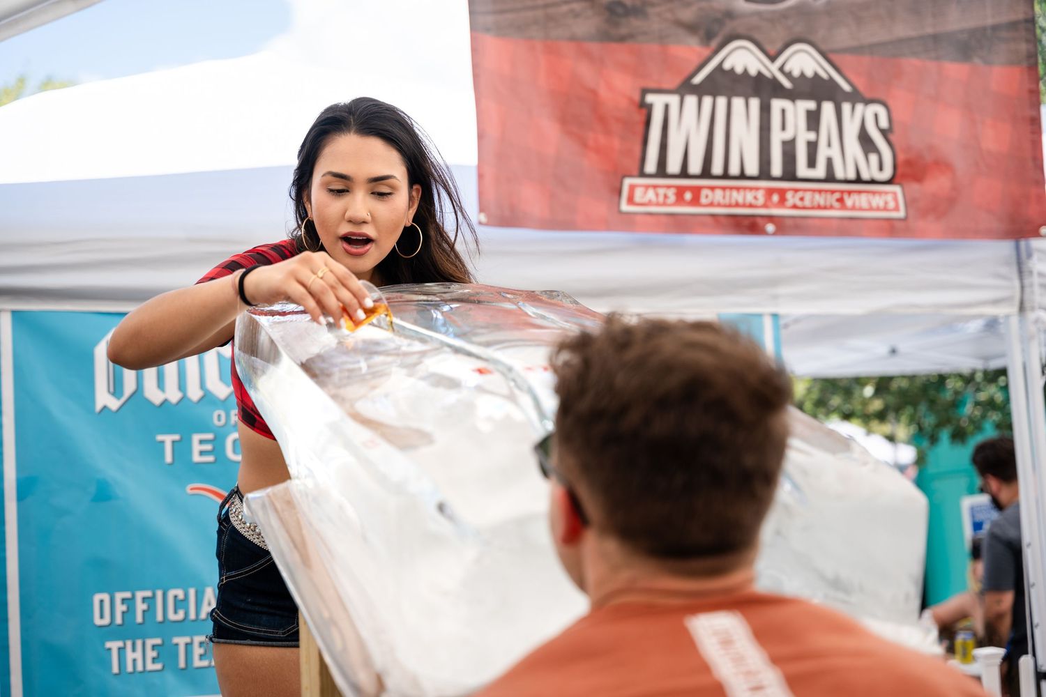 Staff member demonstrating product service at Twin Peaks promotional booth.