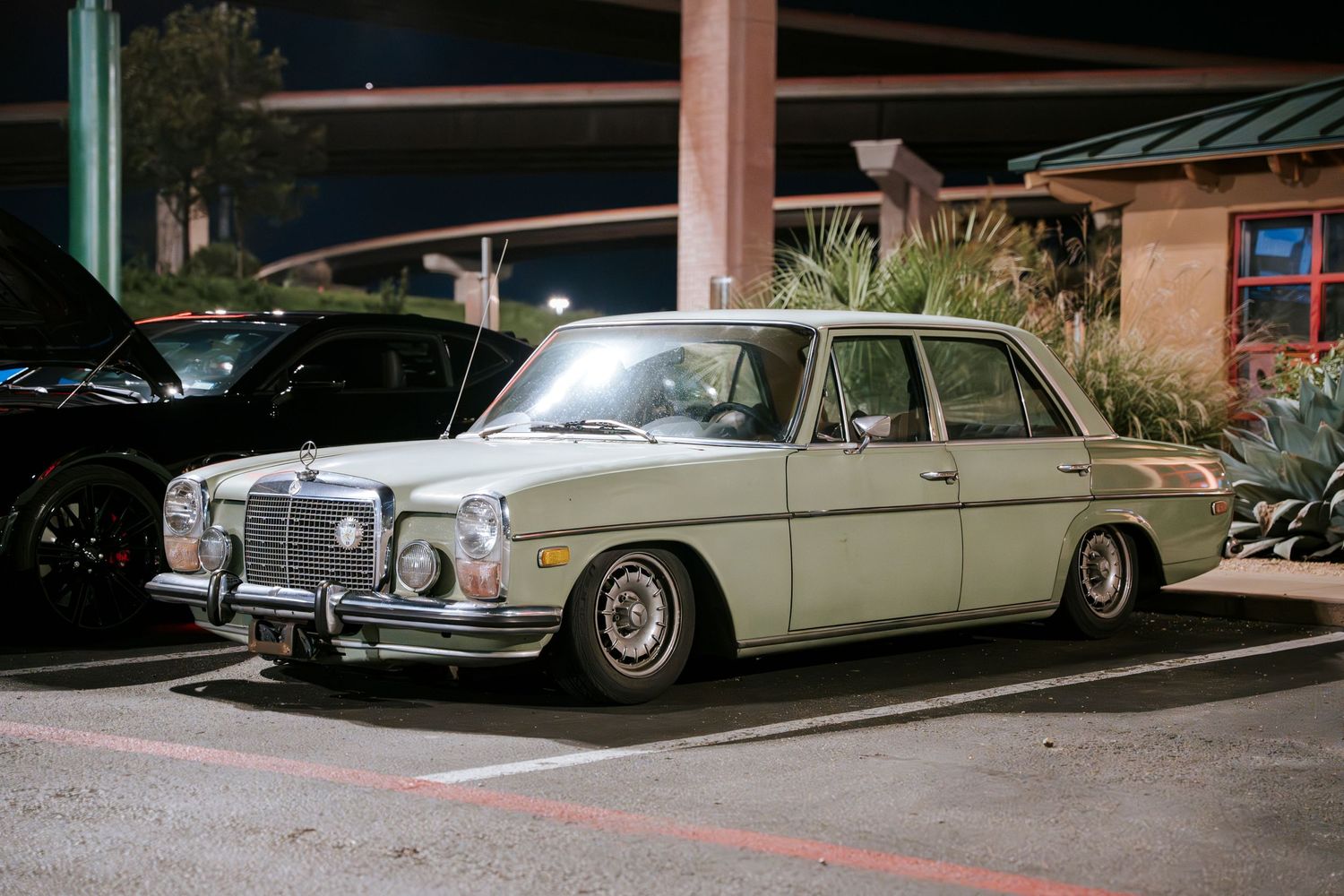 Vintage Mercedes-Benz W108 sedan in cream white showcasing classic styling.