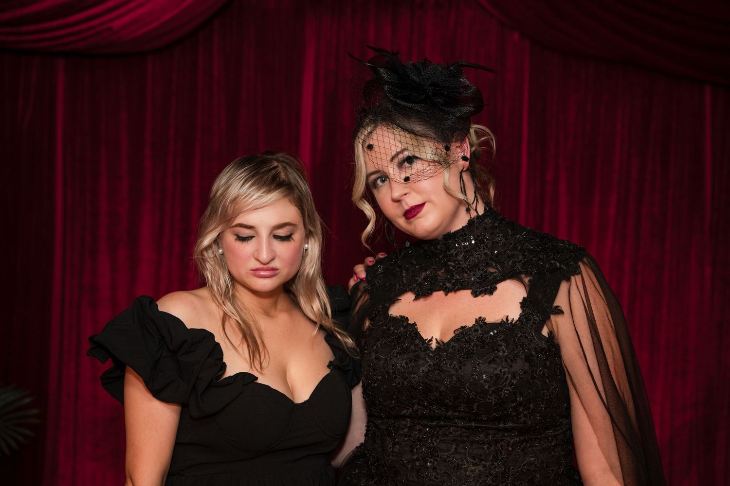 Formal gothic-themed celebration against red velvet curtain background.