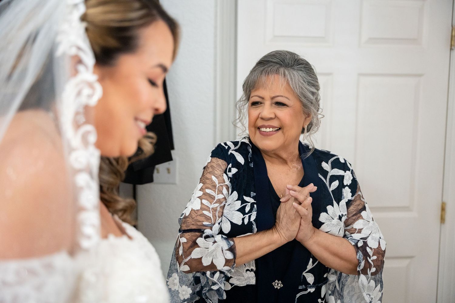 Emotional moment shared during wedding preparations in front of white door.