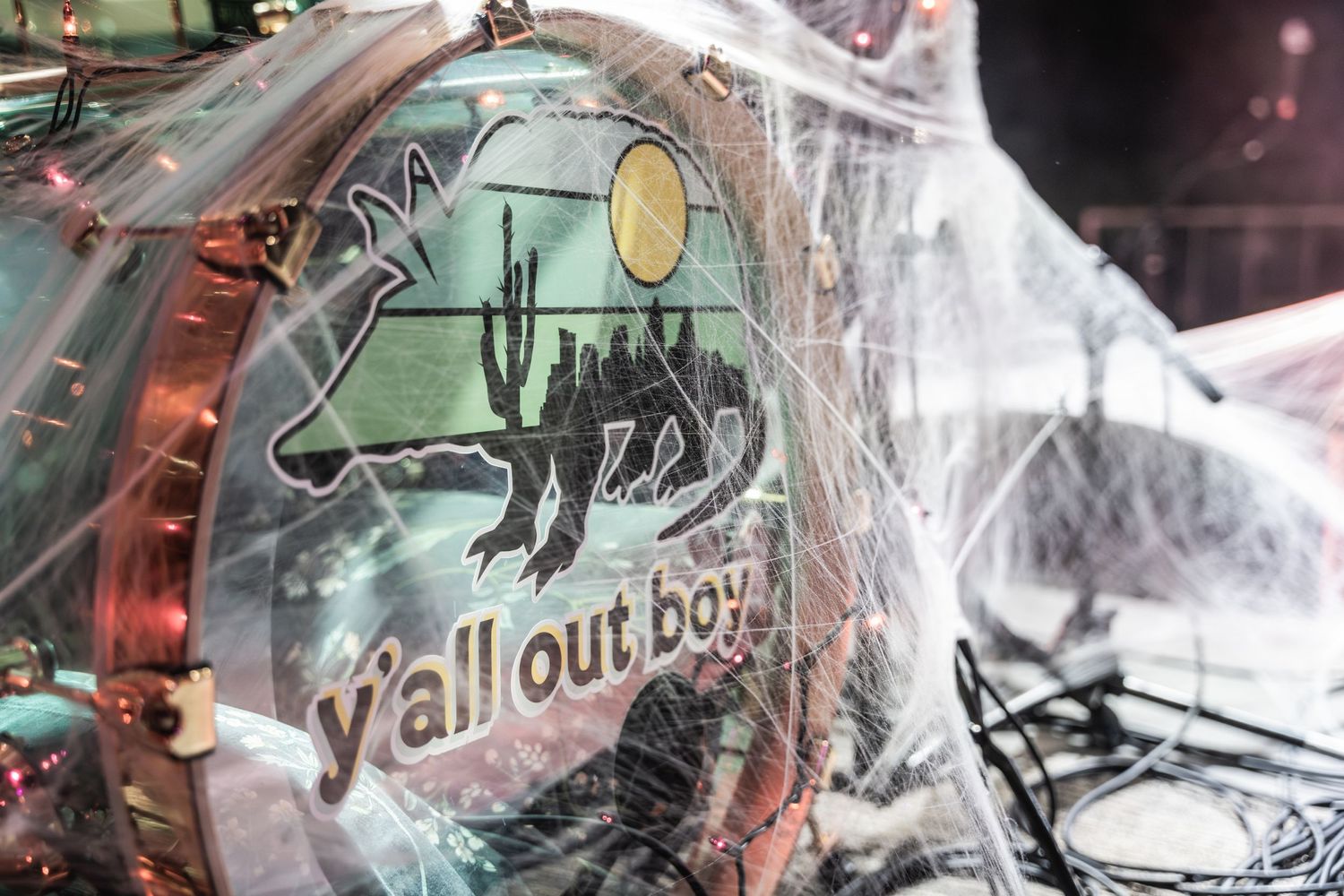 Close-up of Fall Out Boy merchandise with spider artwork against foggy background.