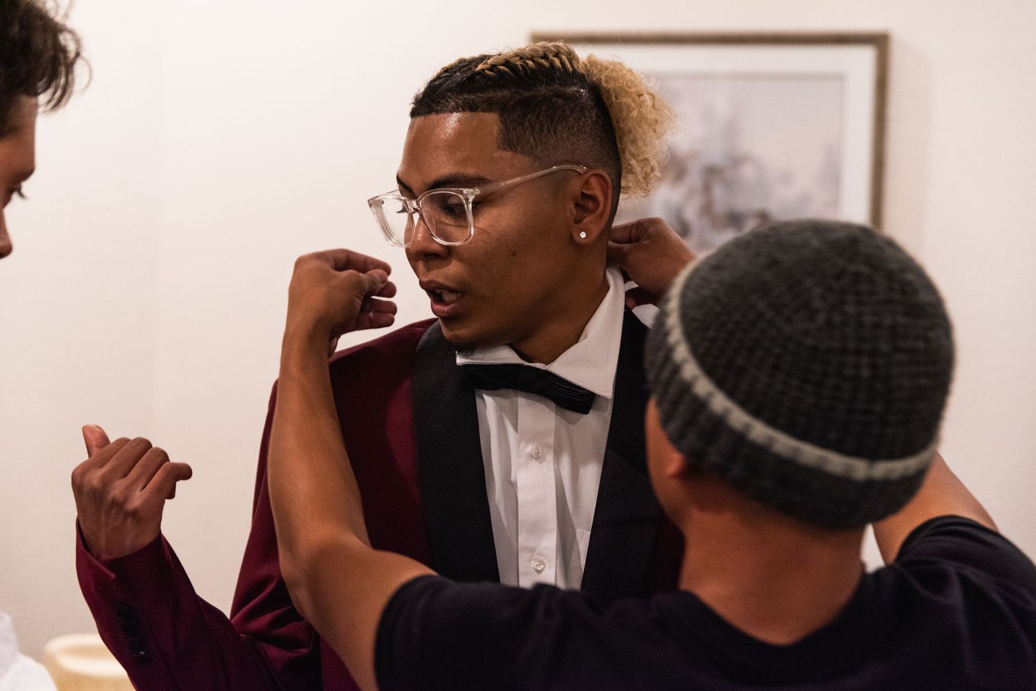 Pre-wedding gathering showing formal bow tie and suit preparations.