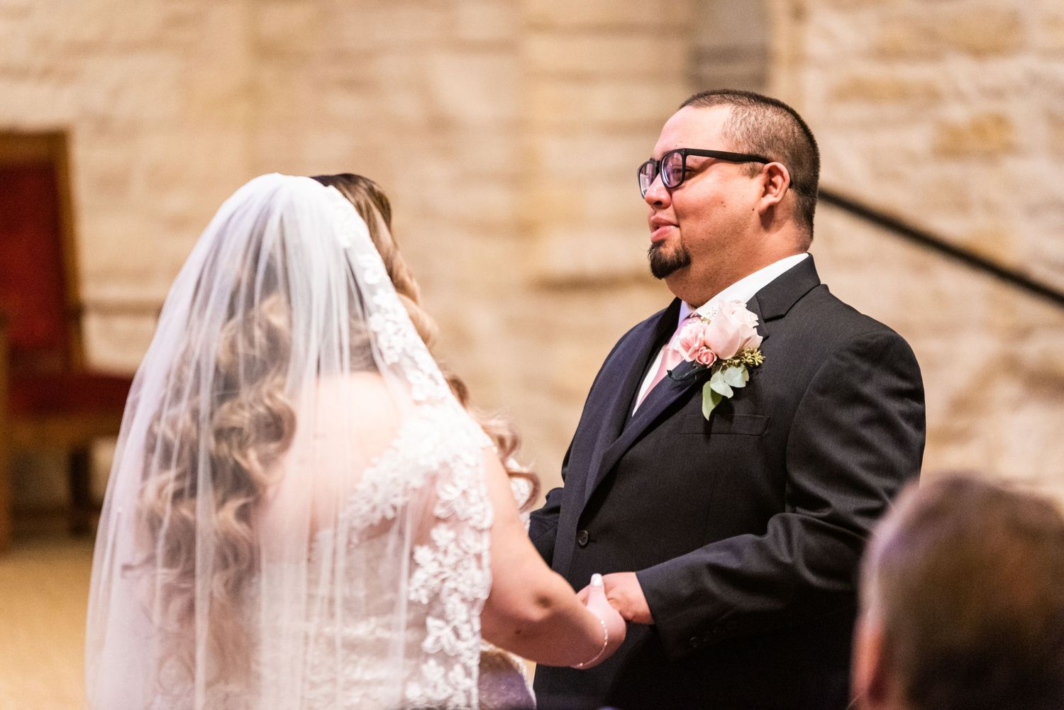 A couple shares a moment during their wedding ceremony in a church setting.
