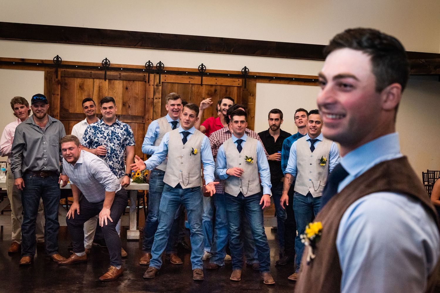 Groomsmen gathered in formal attire at wedding reception venue.