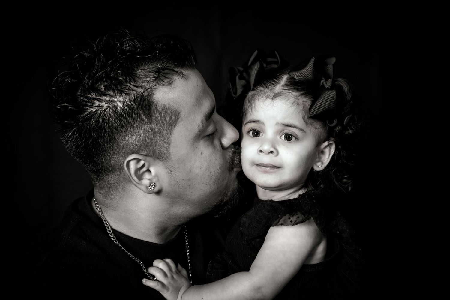 Intimate black and white portrait showing tender moment between parent and child.