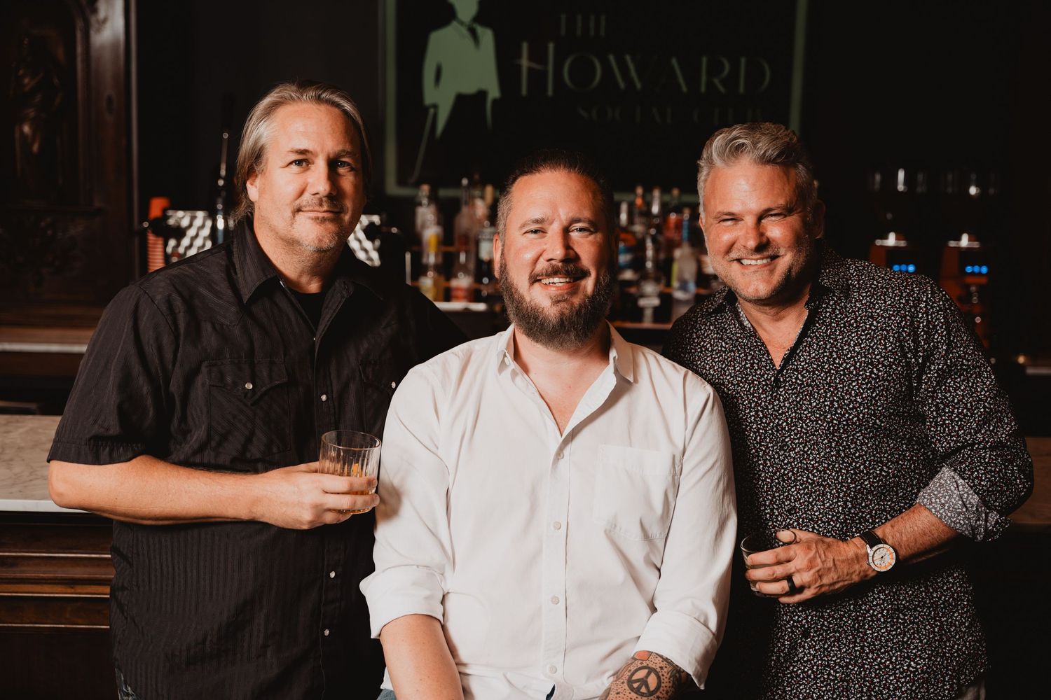 Group portrait at Howard bar with dark wood and elegant decor.