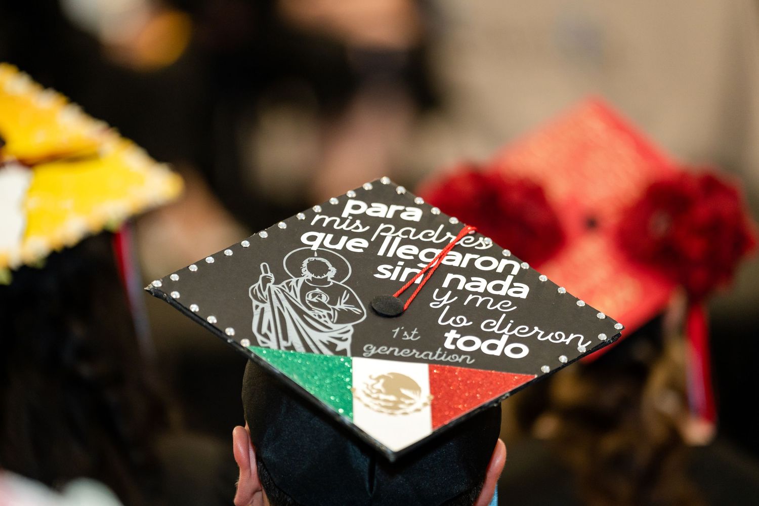 A black graduation cap decorated with Spanish text and a small Mexican flag emblem.
