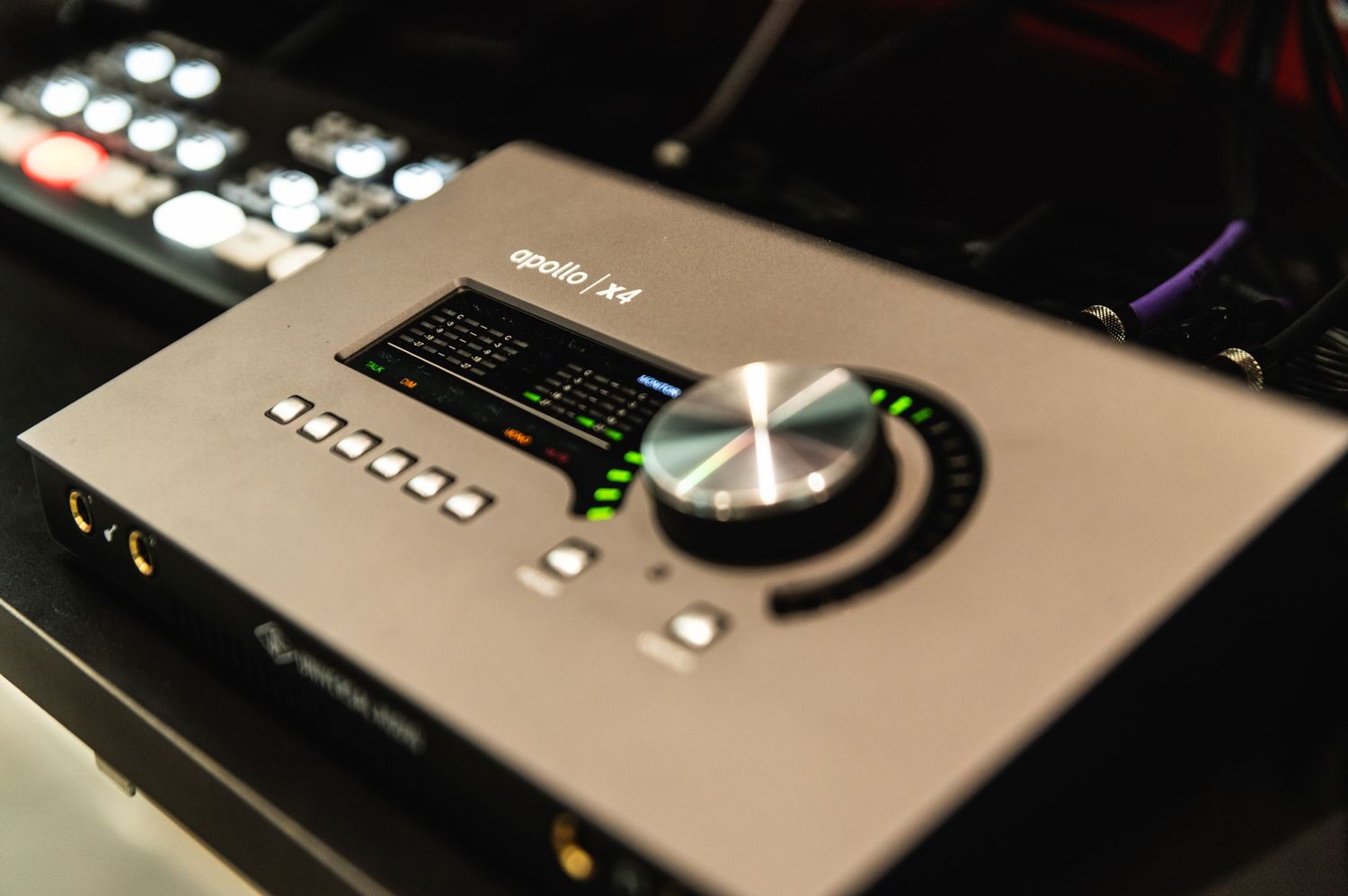 Close-up of professional audio interface with illuminated control dial and digital display.