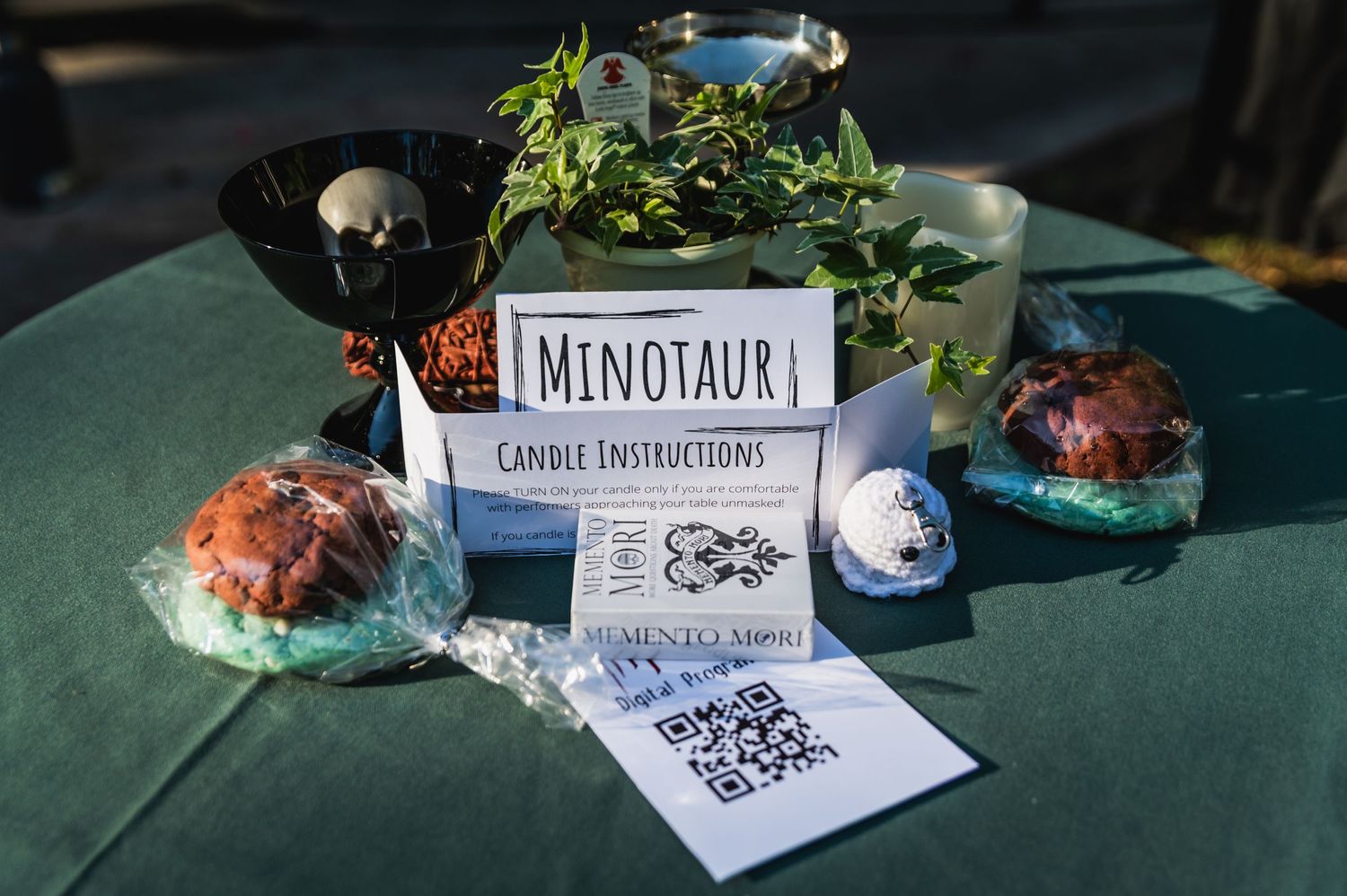 Table setting with Minotaur card display, decorative items and refreshments.
