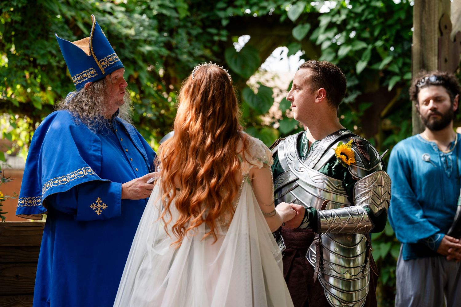 A couple shares an intimate moment during their outdoor wedding ceremony surrounded by guests in a natural setting.