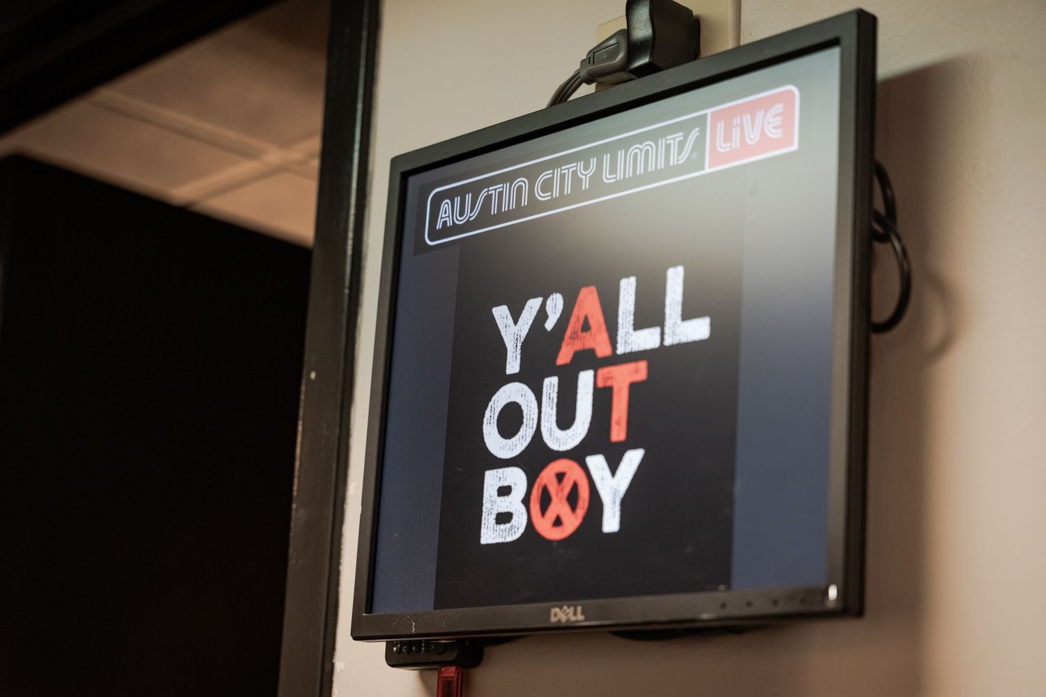 Austin City Limits Live monitor displaying Y'all Out Boy sign at a music venue event.
