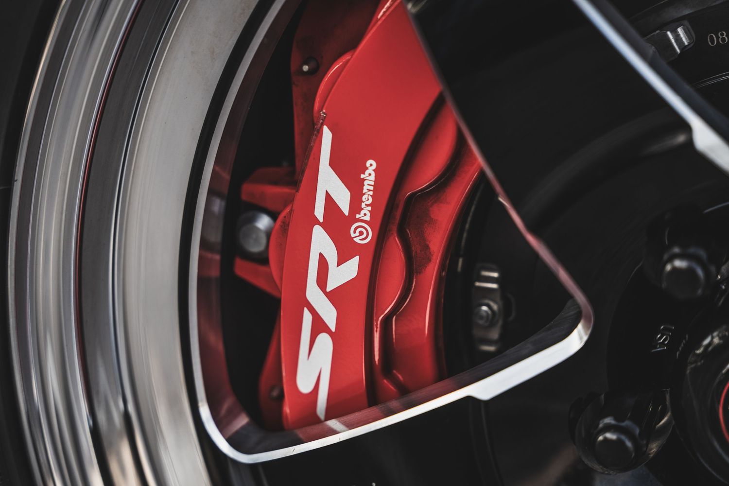 Close-up of a red SR brake caliper behind a sporty wheel rim.