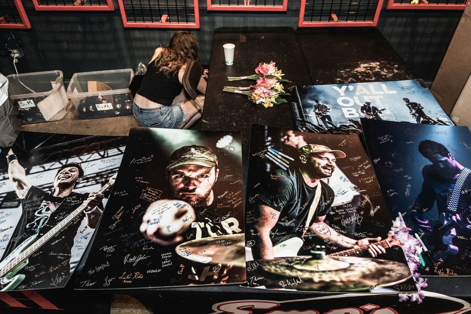 Collection of signed music performance photographs and memorabilia displayed on table.