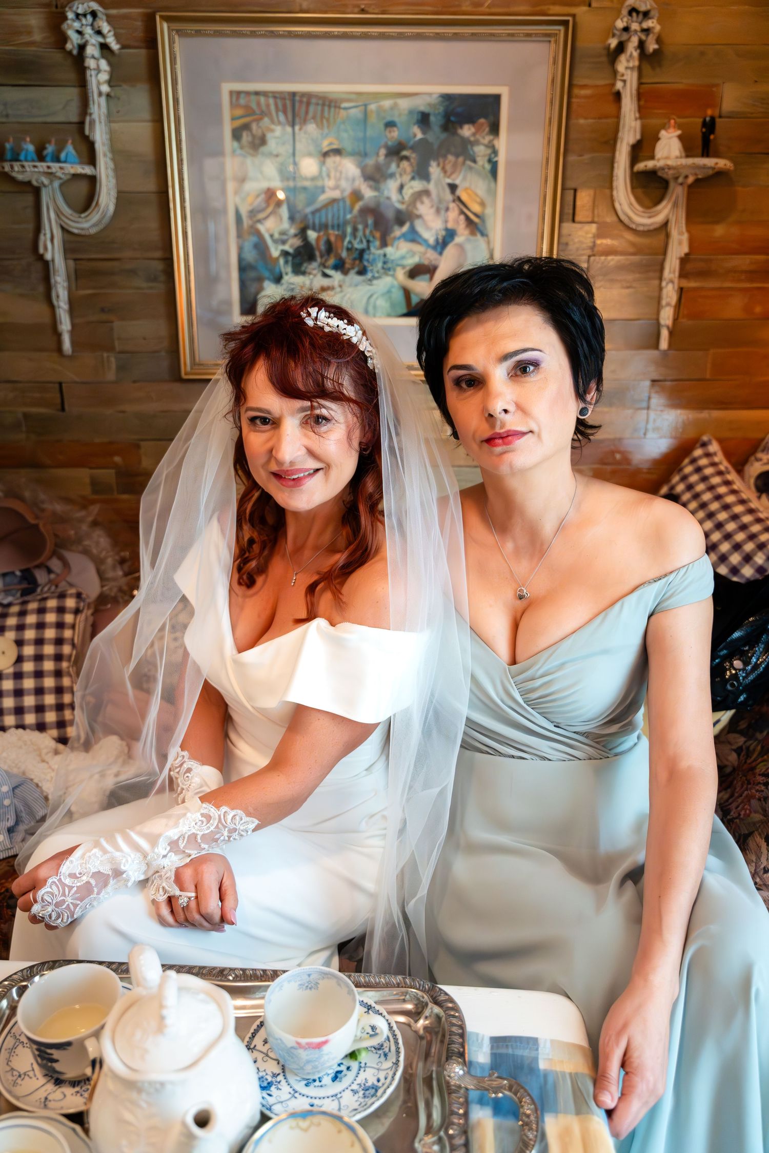 Wedding party members sharing a relaxed moment during preparations with vintage decor and tea service.