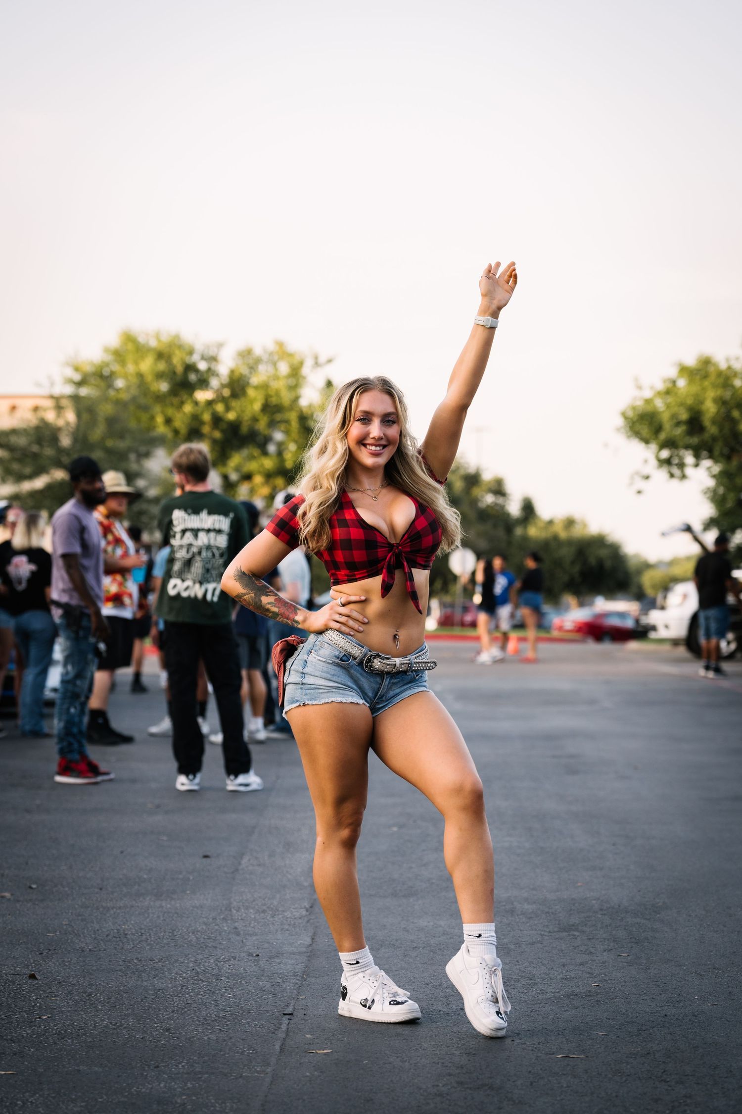 Person dancing outdoors at a casual street gathering.
