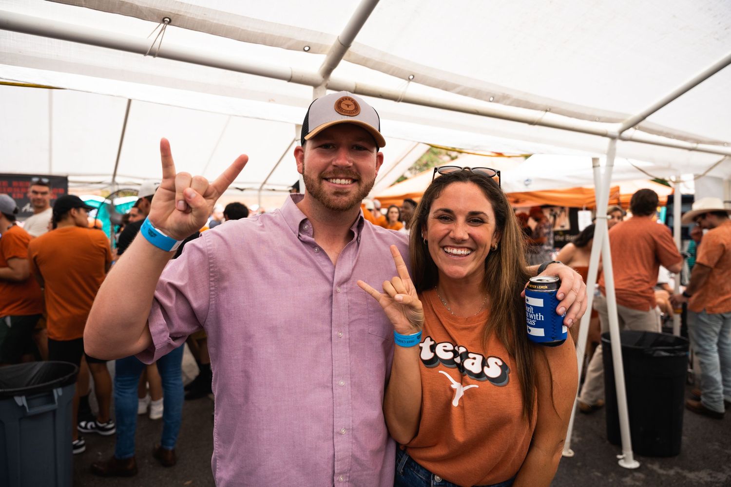 Couple in Texas sports gear celebrating at an outdoor tailgate party.