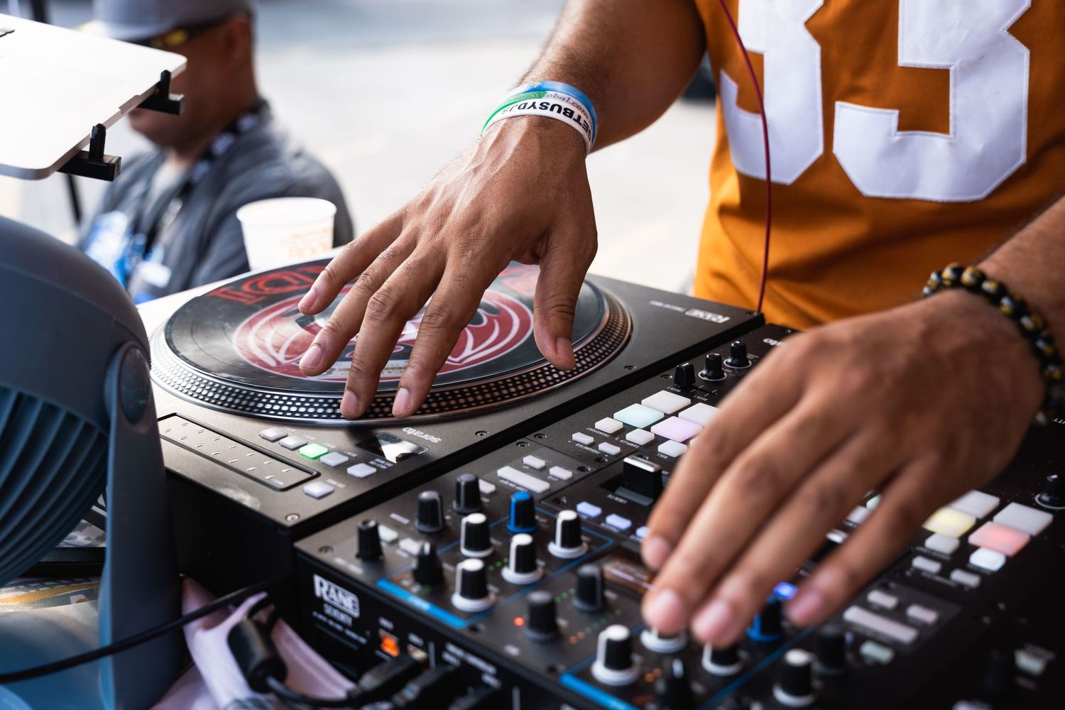 DJ mixing music on turntables at an outdoor event.