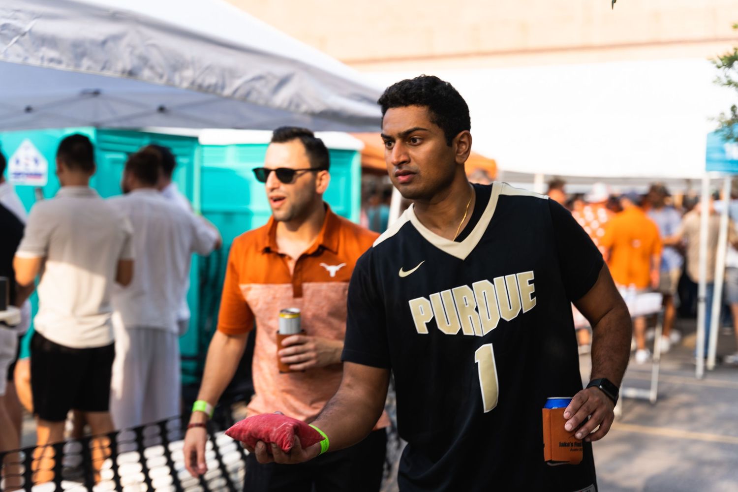 People enjoying an outdoor event with a person wearing a Purdue jersey.