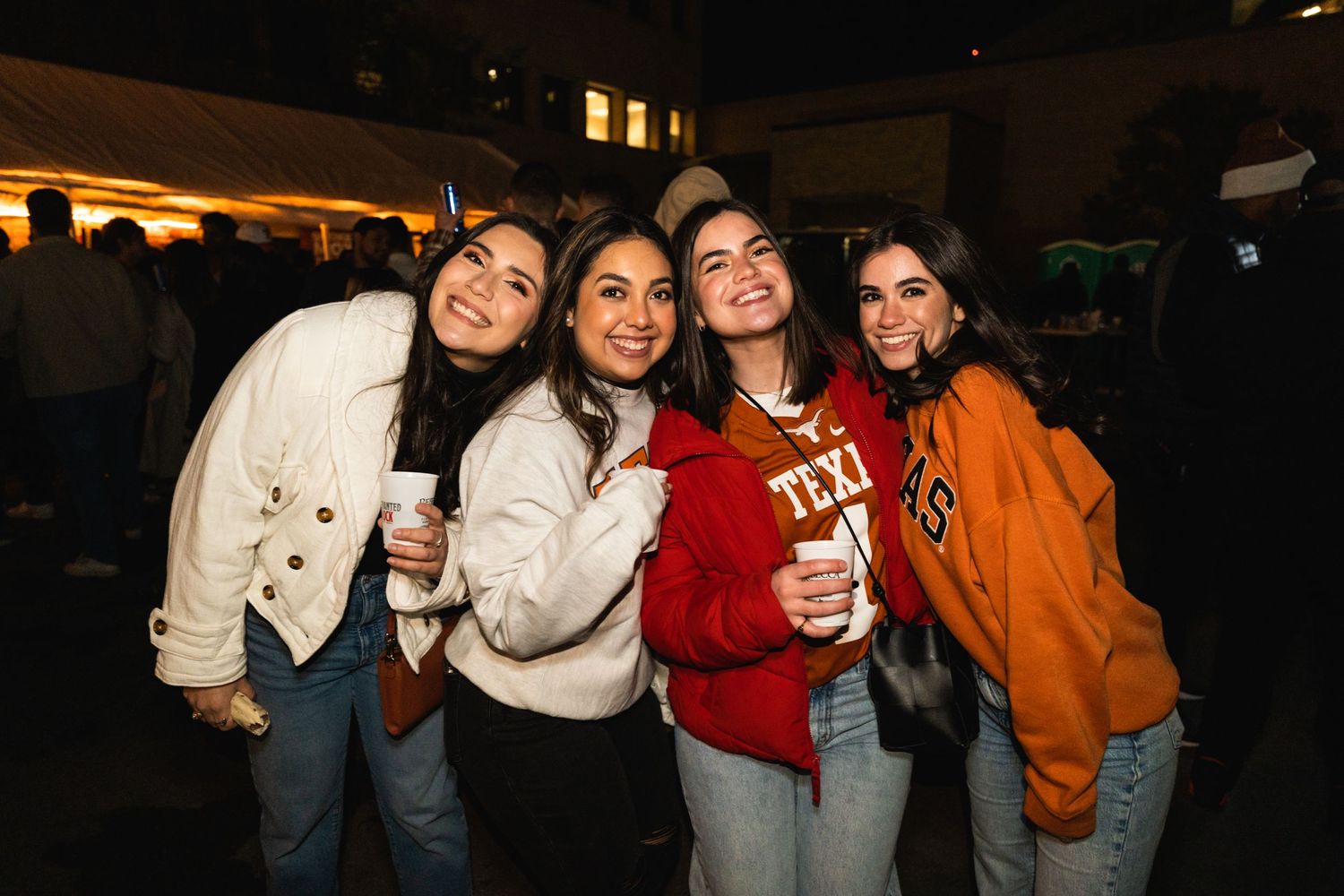 Group of friends posing together at an outdoor nighttime gathering.