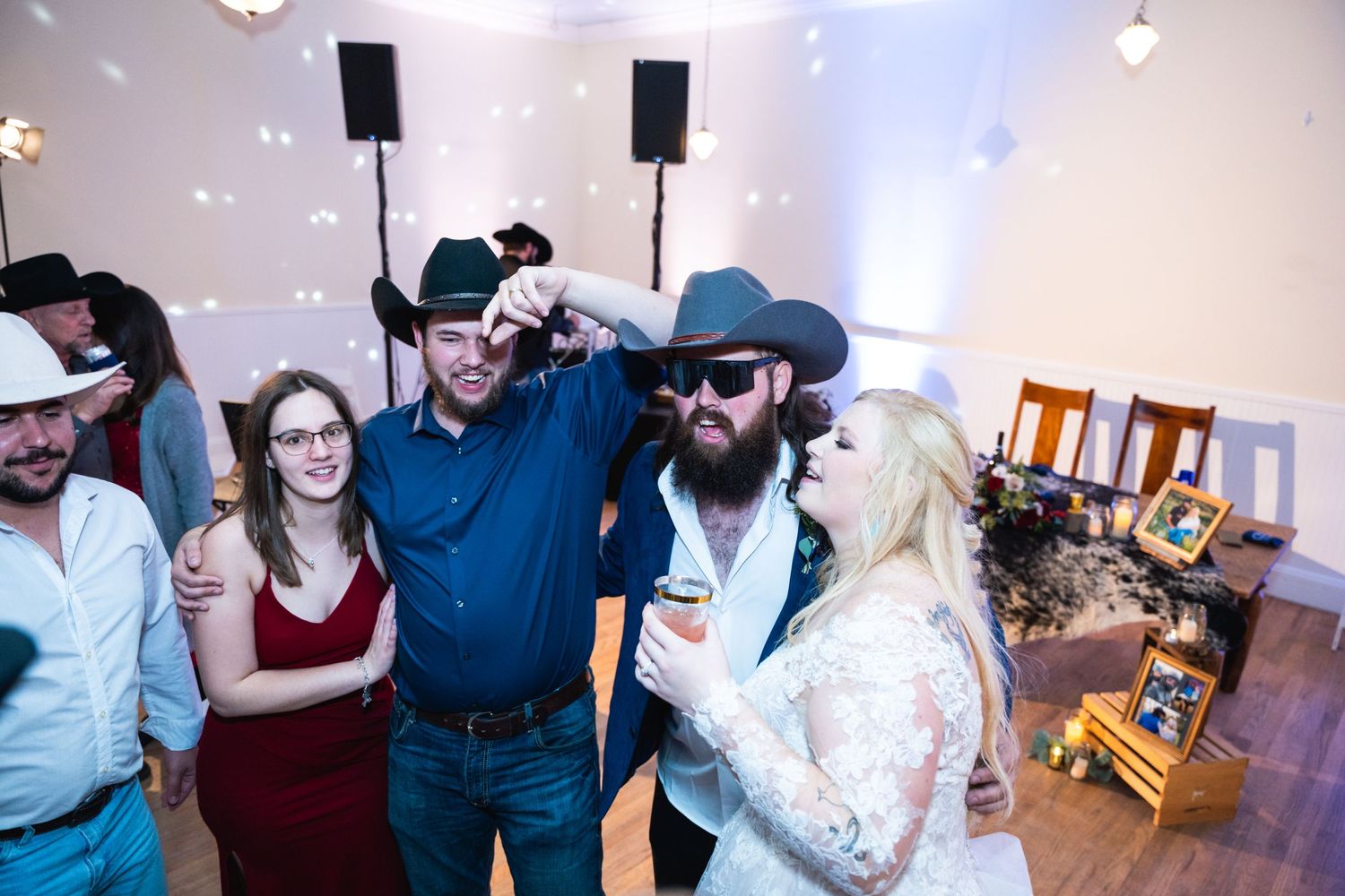 Wedding party shares laughs and fun moments during indoor reception with disco lights.